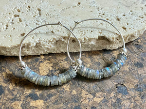 Stunning, large labradorite hoop earrings, crafted from flat labradorite stones that are facet cut on every side to show off their stunning fire and lustre. Sterling silver hoops complete the look. Measurements: 5 cm diameter