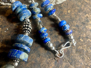 Tribal lapis lazuli and silver necklace, crafted from antique unpolished graduated Afghani lapis lazuli and handmade, vintage and antique tribal silver beads. This stunning, long necklace is finished with a sterling silver clasp and weighs 170 g. Measurements: 68 cm in length