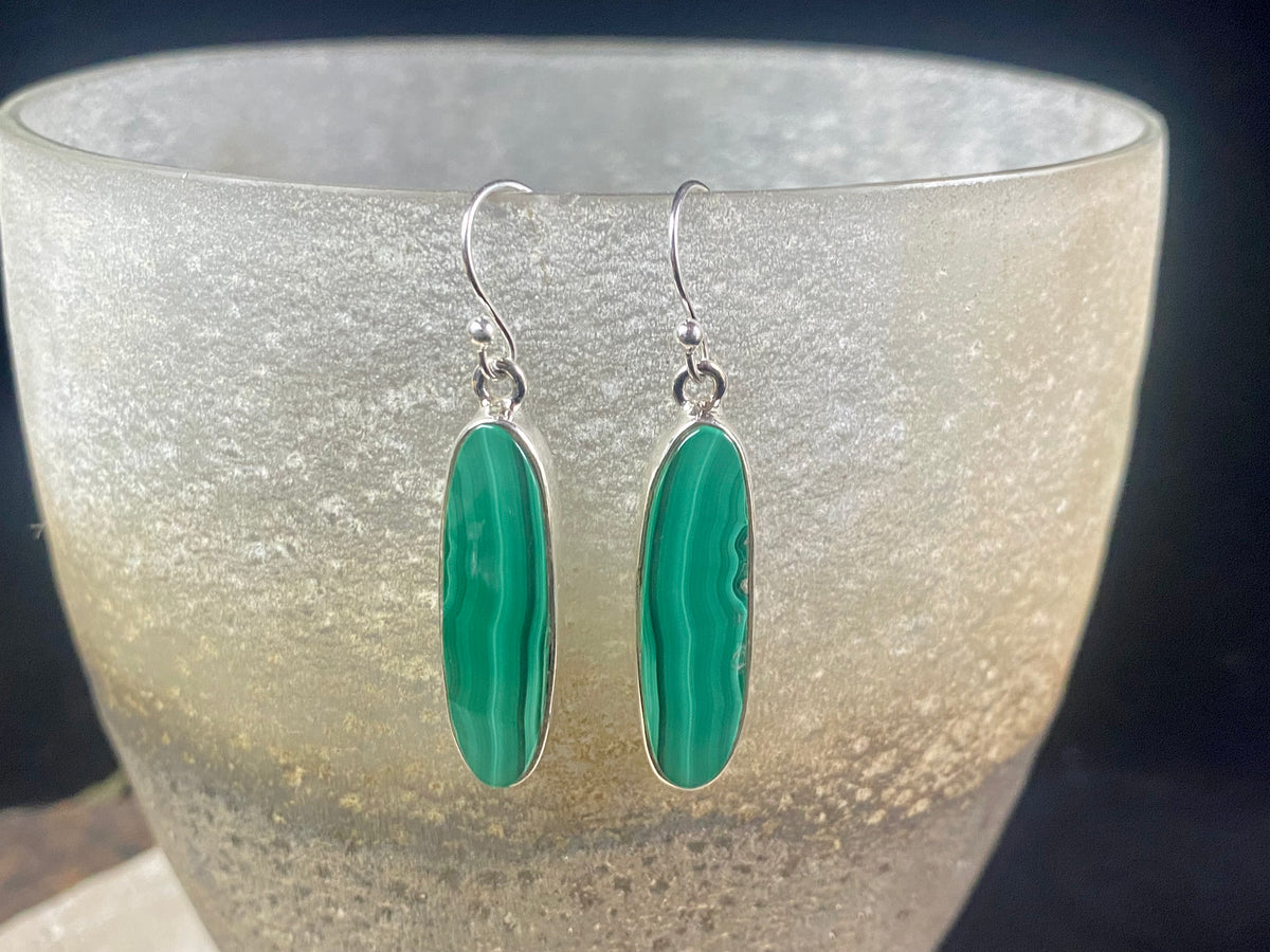 Our elegant earrings feature perfectly matched malachite cabochons set in sterling silver bezels. Finished with sterling silver hooks.