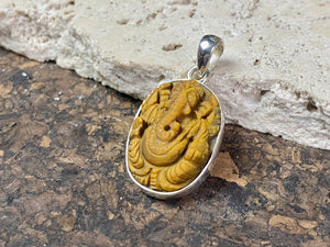 Hand carved Ganesh pendants, tigers eye with sterling silver mount and bail.  Dimensions 3.7 x 1.7 x 0.7 cm