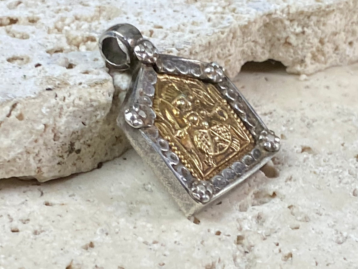 antique tribal amulet depicting Durga in Kali form. High grade silver with a 22 kt gold finish over the amulet face. Early 20th century or earlier. This is a unique amulet in its depiction of the goddess in tribal headdress and its use of silver and gold.  Height 2.7 cm including bail, width 2 cm