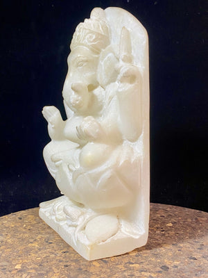 Hand carved marble stone statue of Ganesh. Our Ganesh sits on a lotus pedestal, while his mouse sits at his feet. One of his right hands is upraised in the gesture of protection, while the other holds his favourite ladoo sweet. Measurements: 22 cm high, 14 cm wide, 6 cm depth