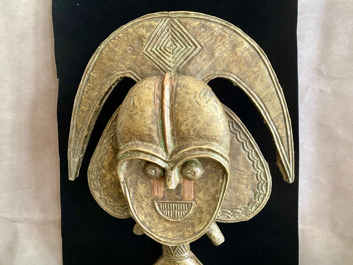 Mbulu-ngulu or funerary reliquary protective figure. Kota people, Gabon, West Africa. Mid to late 20th century. Wood with copper and brass decorative overlay. Height 54 cm, width at widest point 30 cm.