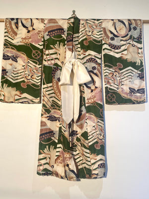 Small, hand sewn child's kimono suitable for either sex. A tasteful design features greens, tans, navy, lilac and pale blue colours in an abstracted design reminiscent of its era. Padded and lined. Hand stitched silk ties with fine thread tassel detailing. No damage, excellent condition. Circa 1950's.