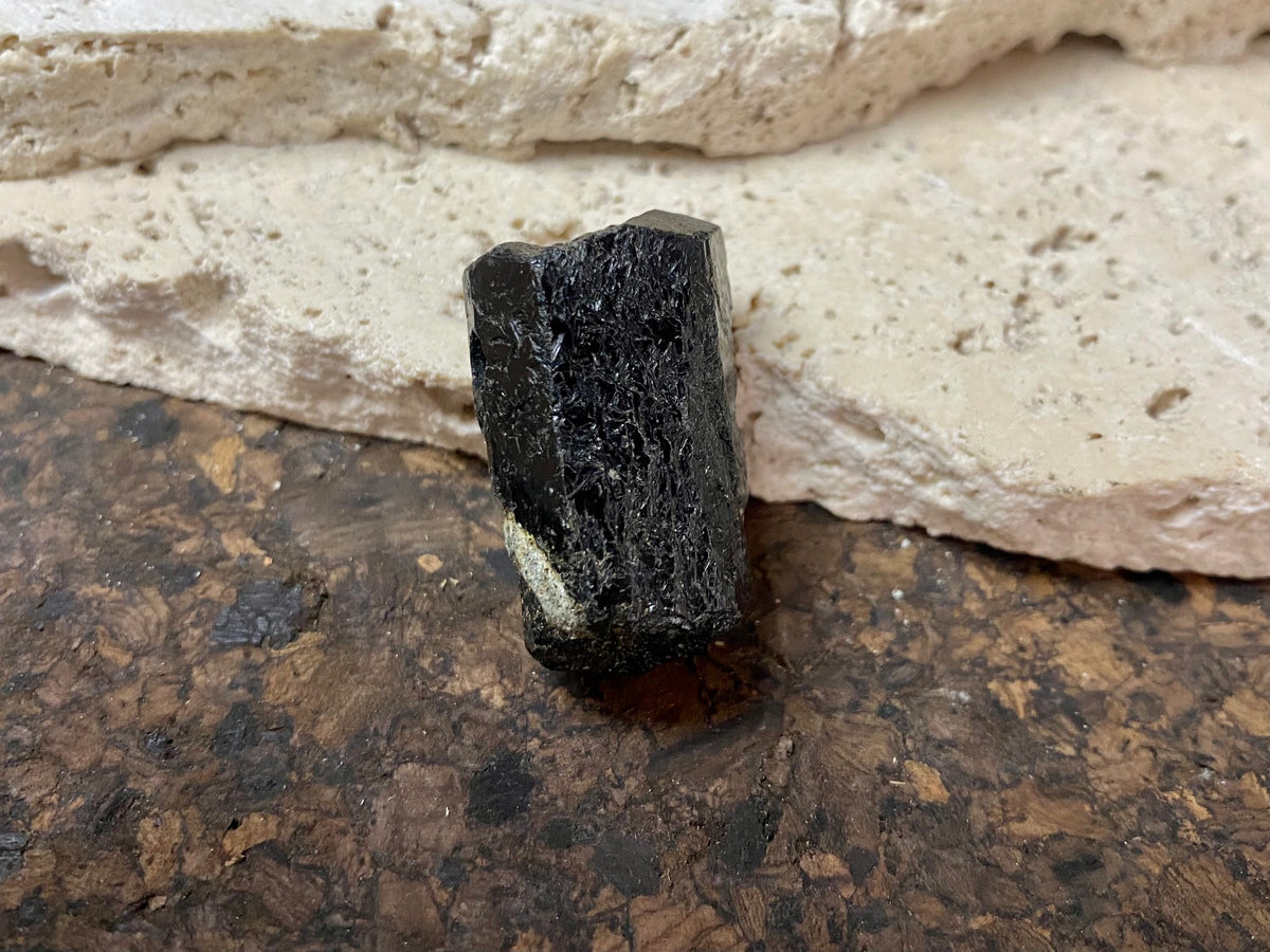 Natural six sided black tourmaline crystal. This has a large hole drilled through the top.  Measurements: 3.3 cm length, width 1.4 x 1.8 cm