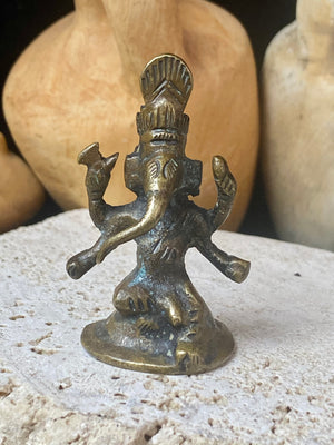 This exquisite miniature Ganesh statue features fine, elegant features, a face rubbed through many years of worship and a high tribal headdress typical of the eastern states of India. Early 20th century, India, bronze alloy.  Measurements: height 6.5 cm, width 3.2 cm, depth 2.5 cm