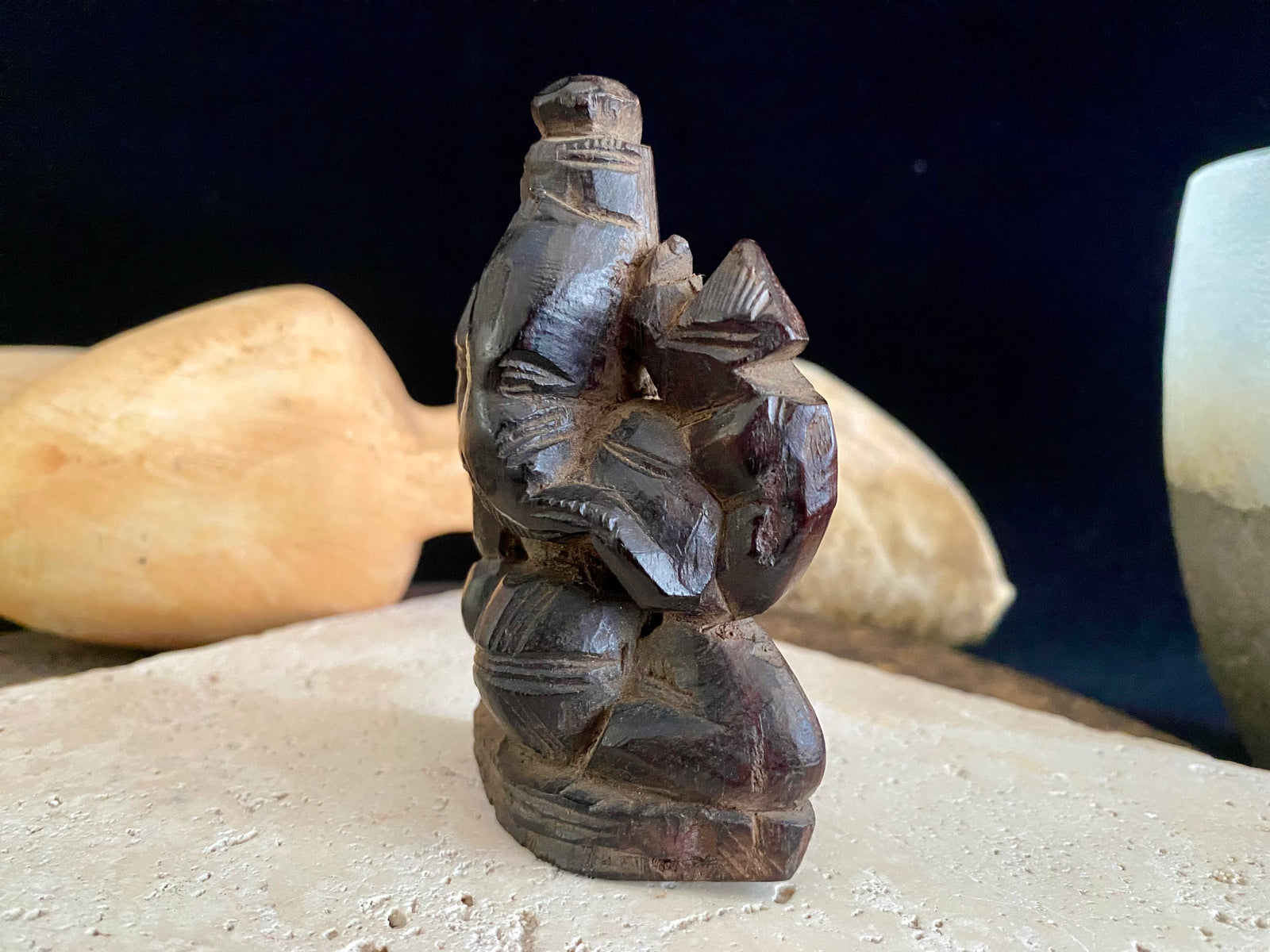 Small rosewood carving of Ganesh. Early 1900's, from east India. Two arms, seated, with his trunk to the left.  Height 9.5 cm, width  7 cm