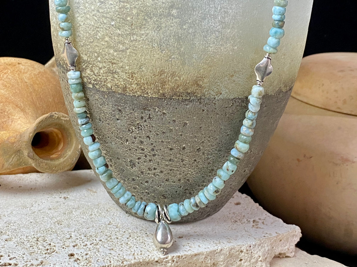 Light blue blue necklace of tumbled, facet cut graduated larimar, highlighted with Rajasthani silver beads and a beautiful central drop pendant. Finished with sterling silver findings and hook clasp. and a hook clasp. Measurements: 46 cm (18") length