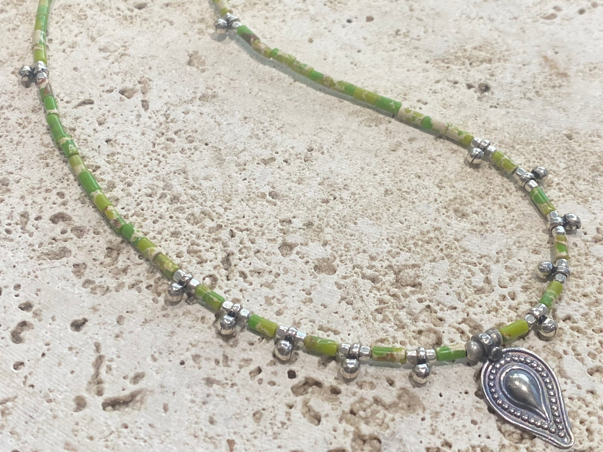 This very pretty necklace is made from tube cut imperial green jasper, highlighted with traditional handmade sterling silver Rajasthani ball beads and a tribal pendant. Finished with sterling silver findings and hook clasp. The pendant represents the shiva lingam/yoni. Length 40.5 cm