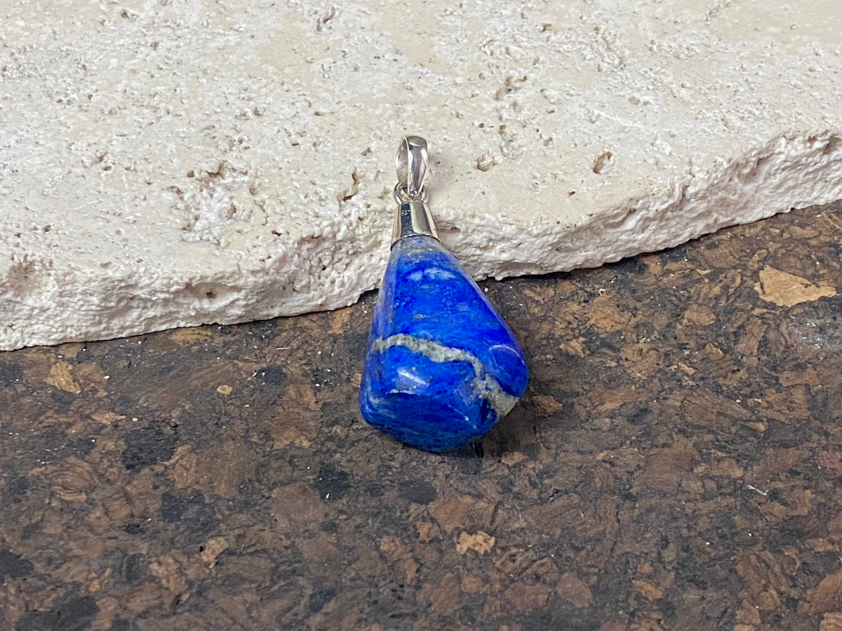 Freeform lapis lazuli top mounted pendant. The rich blue lapis originates from Afghanistan. Set in sterling silver with a generous bail to take a sizeable cord or chain. Height  5.5 cm