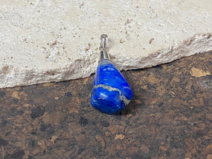 Freeform lapis lazuli top mounted pendant. The rich blue lapis originates from Afghanistan. Set in sterling silver with a generous bail to take a sizeable cord or chain. Height  5.5 cm