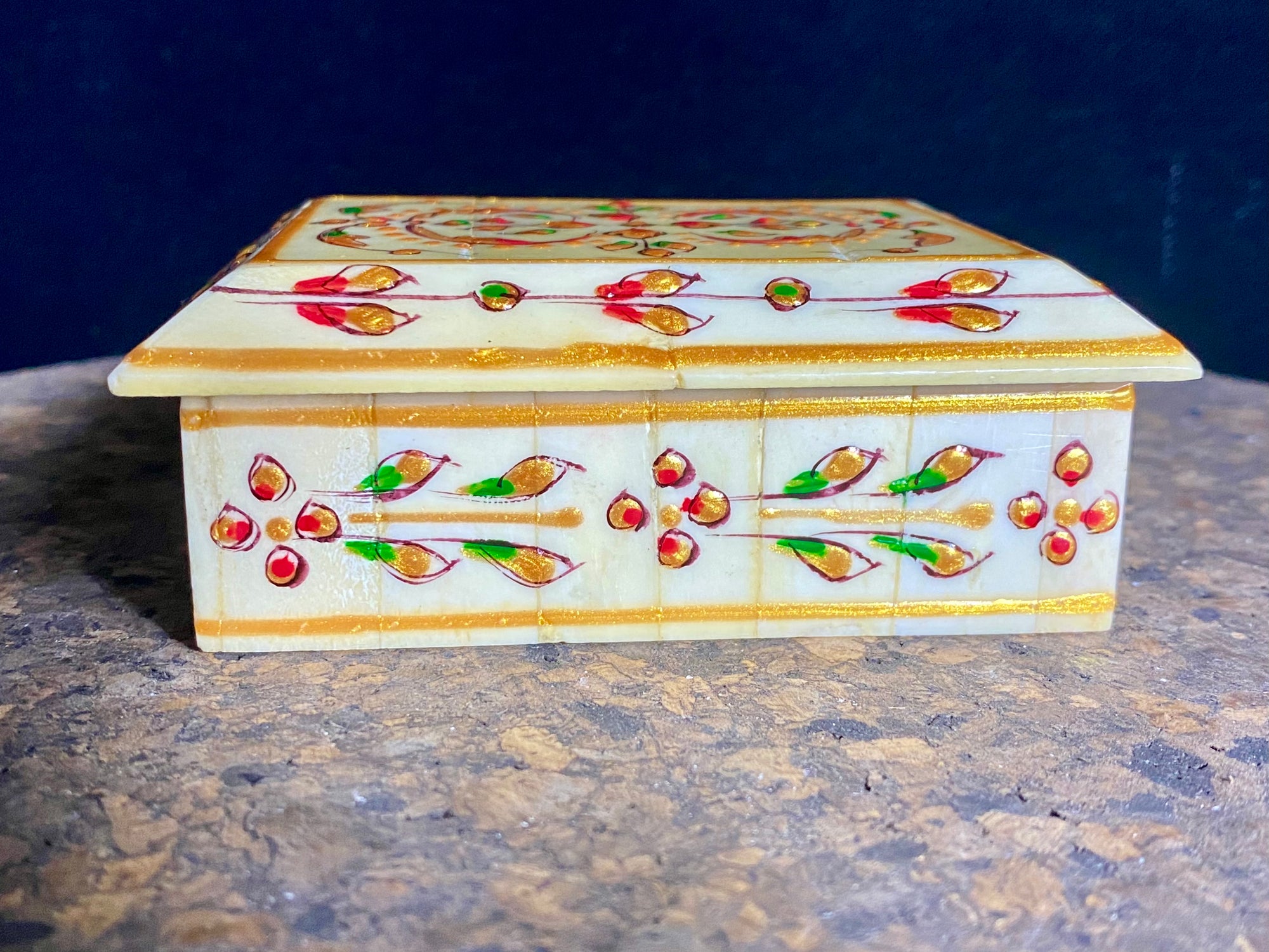 A compact trinket box, hand crafted from wood overlaid with polished hand shaped panels of camel bone, which are then exquisitely hand painted.  Measurements: 10 cm x 7.5 cm, height 4 cm 