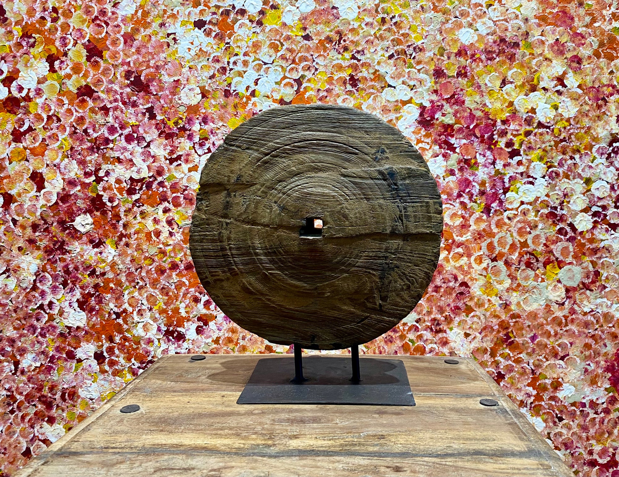 This lovely wooden pulley or spinning wheel, made from solid teak, stands on an iron stand and is repurposed as a piece of art. Originating from northern India and dating back to the early 20th century. Measurements: diameter 33cm, height 37.5cm, depth width of stand 8 cm