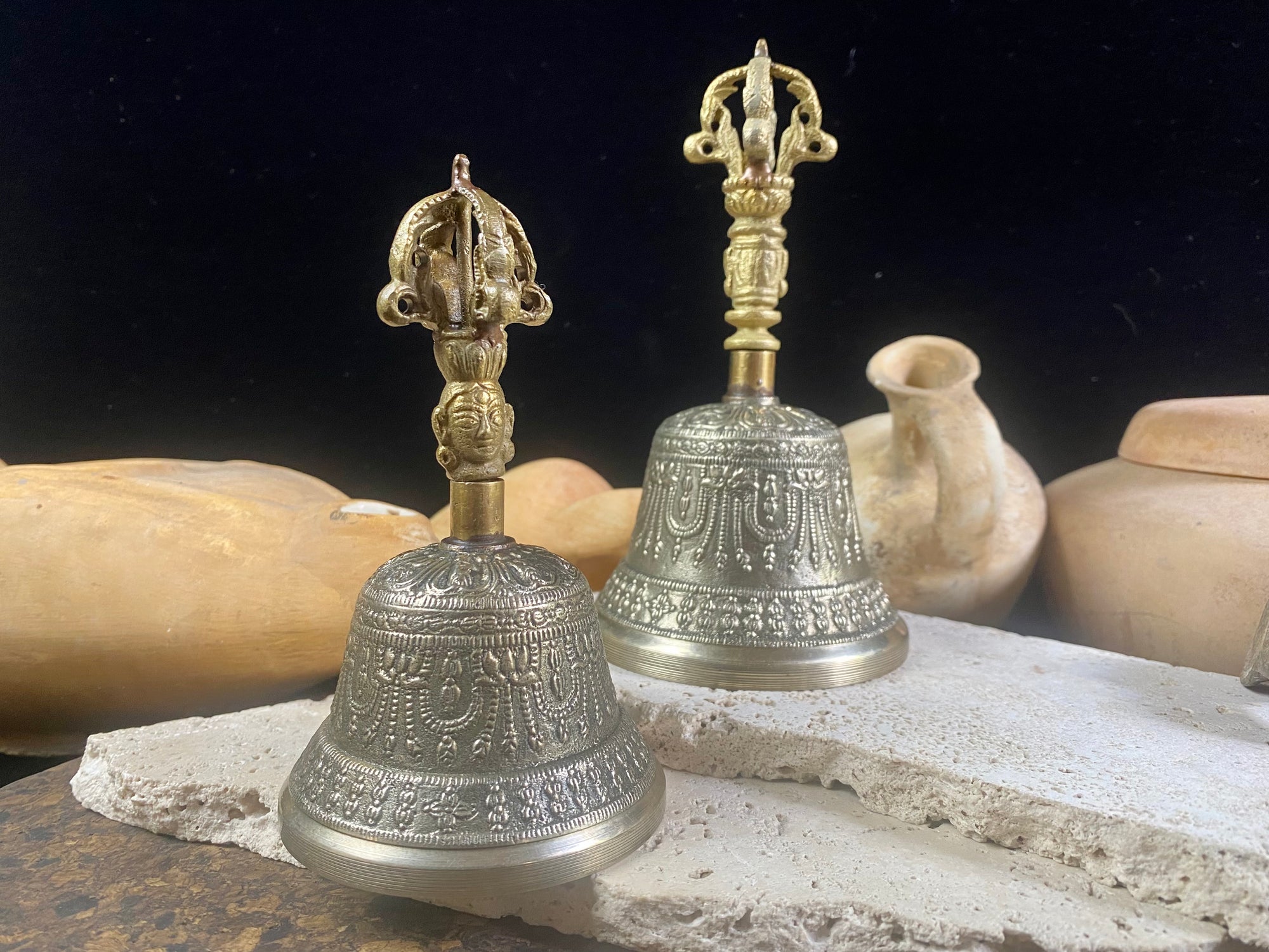 Tibetan Buddhist bells in two sizes. They feature fine detailing, are encircled with the mantra Om Mani Padmi Hum and are topped with the image of the Buddha and the dorje. These very high quality bells have a beautiful tone, the larger is deeper and richer, the smaller is higher and sweeter. Please watch our two videos to hear their sound.  Measurements:  Large: height 16 cm, diameter 9 cm Small: height 13 cm, diameter 7.5