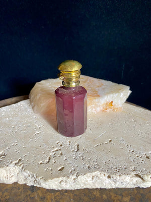 Small cranberry glass perfume bottles with hinged flip top brass lids.&nbsp;