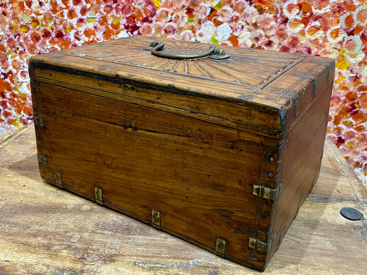 A lovely old southern Indian cash box with carved top and original brass trim, handle and hinges. Fitted with two small shelves inside. Made from teak, this would make a lovely trinket box, key box, jewellery, watch or cufflink box Circa 1880 - 1920. Measurements: length 27.5 cm  x depth 19 cm, height 15 cm.