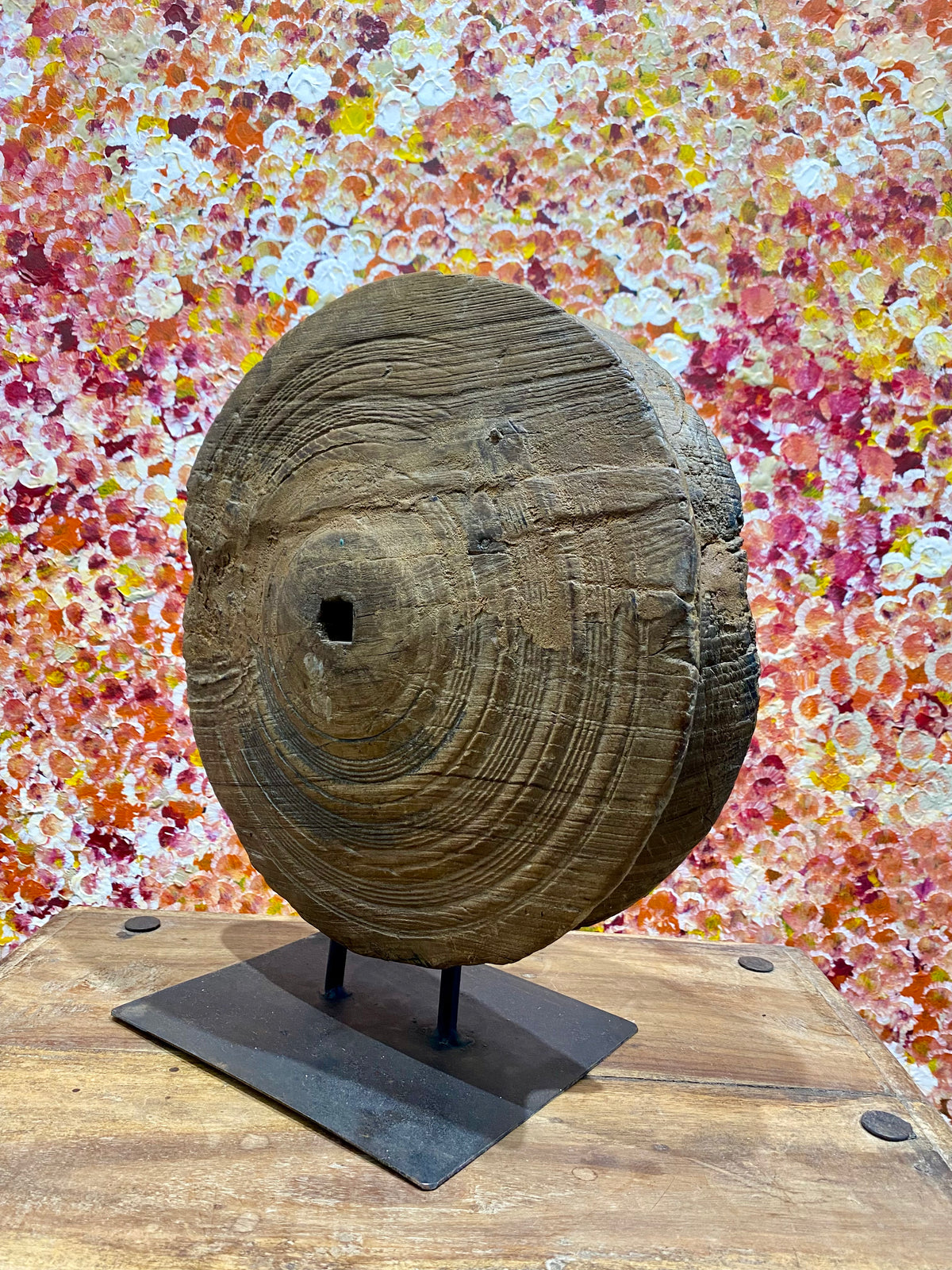 This lovely wooden pulley or spinning wheel, made from solid teak, stands on an iron stand and is repurposed as a piece of art. Originating from northern India and dating back to the early 20th century. Measurements: diameter 33cm, height 37.5cm, depth width of stand 8 cm