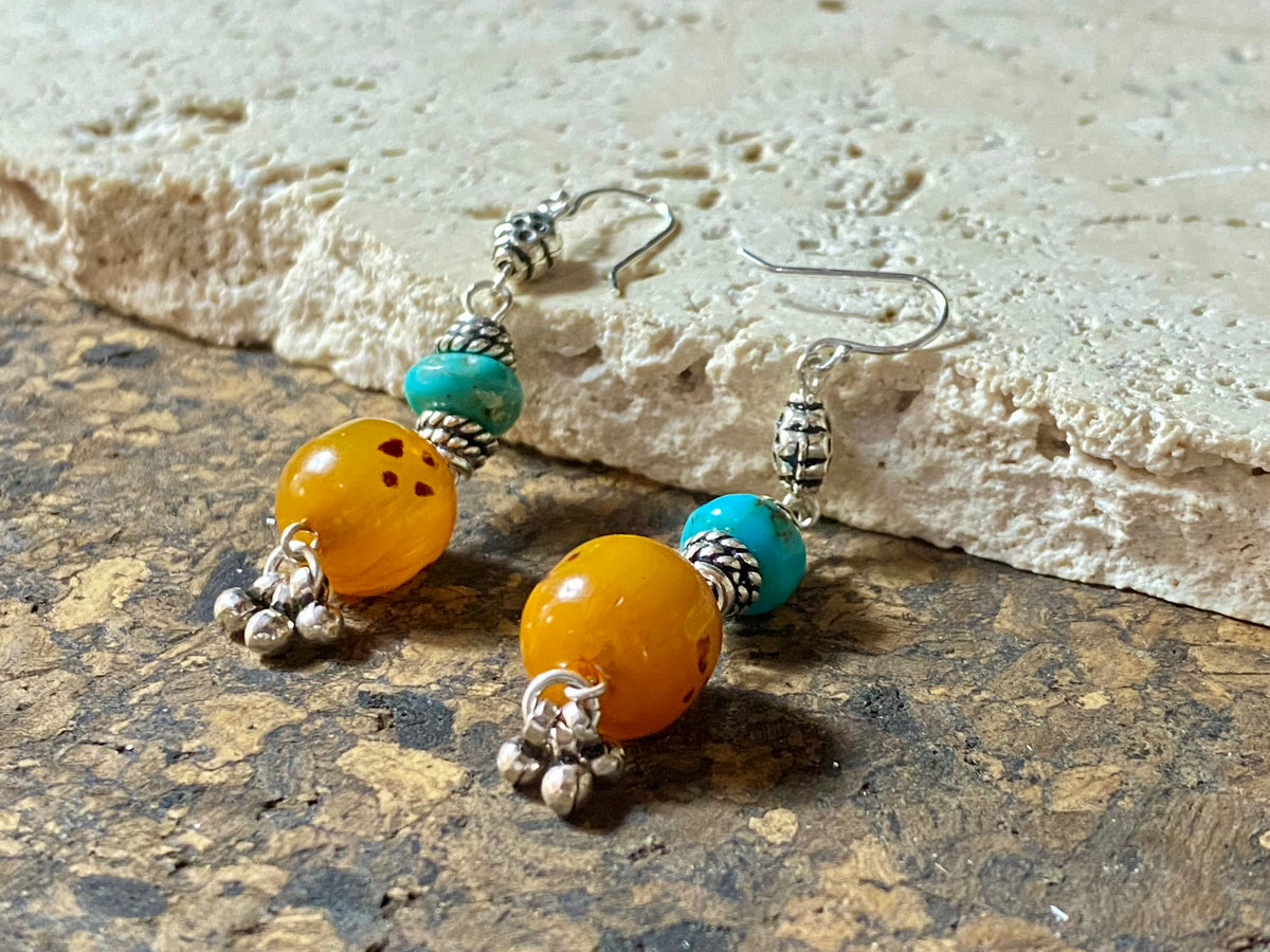 These exotic earrings were created from vintage copal amber beads topped with Arizona turquoise and handmade sterling silver beads, finished with sterling silver hooks.These are a one-off earring design that are very light and easy to wear. Length 5.8 cm including hook