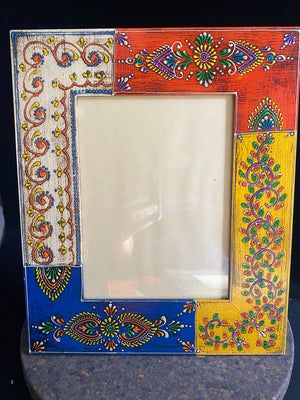 <p>Bright, hand painted picture frame with glass inset window. Set it vertically or horizontally depending on the size of your picture. Hand made in India.</p> <p>Measurements: Outside frame 25 x 20 cm, inside window 14 x 9 cm</p>