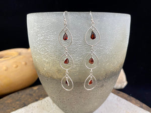 Beautiful garnet earrings featuring a sterling silver chandelier mount with three perfect facet cut teardrop garnets of superb quality. Light and easy to wear.  Measurements: 7 cm including hook 