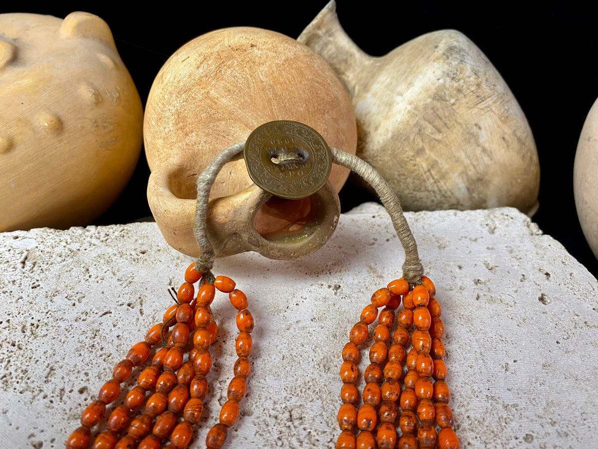 Vintage Naga long multistrand necklace made up of old ceramic beads with wrapped cotton ends and a coin button as fastener.  Measurements: 74 cm length
