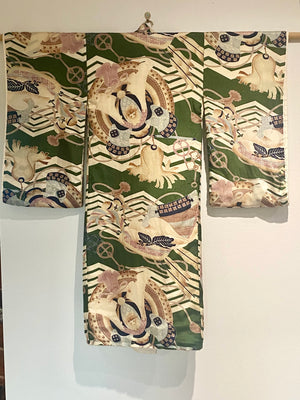 Small, hand sewn child's kimono suitable for either sex. A tasteful design features greens, tans, navy, lilac and pale blue colours in an abstracted design reminiscent of its era. Padded and lined. Hand stitched silk ties with fine thread tassel detailing. No damage, excellent condition. Circa 1950's.