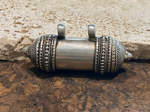 Amulet box or prayer box, these very solid pendants open at one end. Two large bails that even a thick cord or chain will pass through.  White metal.  Length 8 cm, diameter 1.8 cm