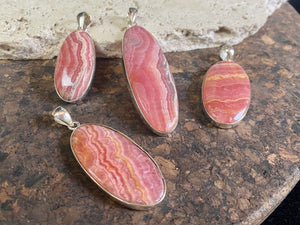 The most beautiful rhodochrosite we've ever seen. Every piece tells a story, all set in sterling silver bezels with generous bails to take the largest of chains or cords. These are beautiful statement pieces of jewellery.