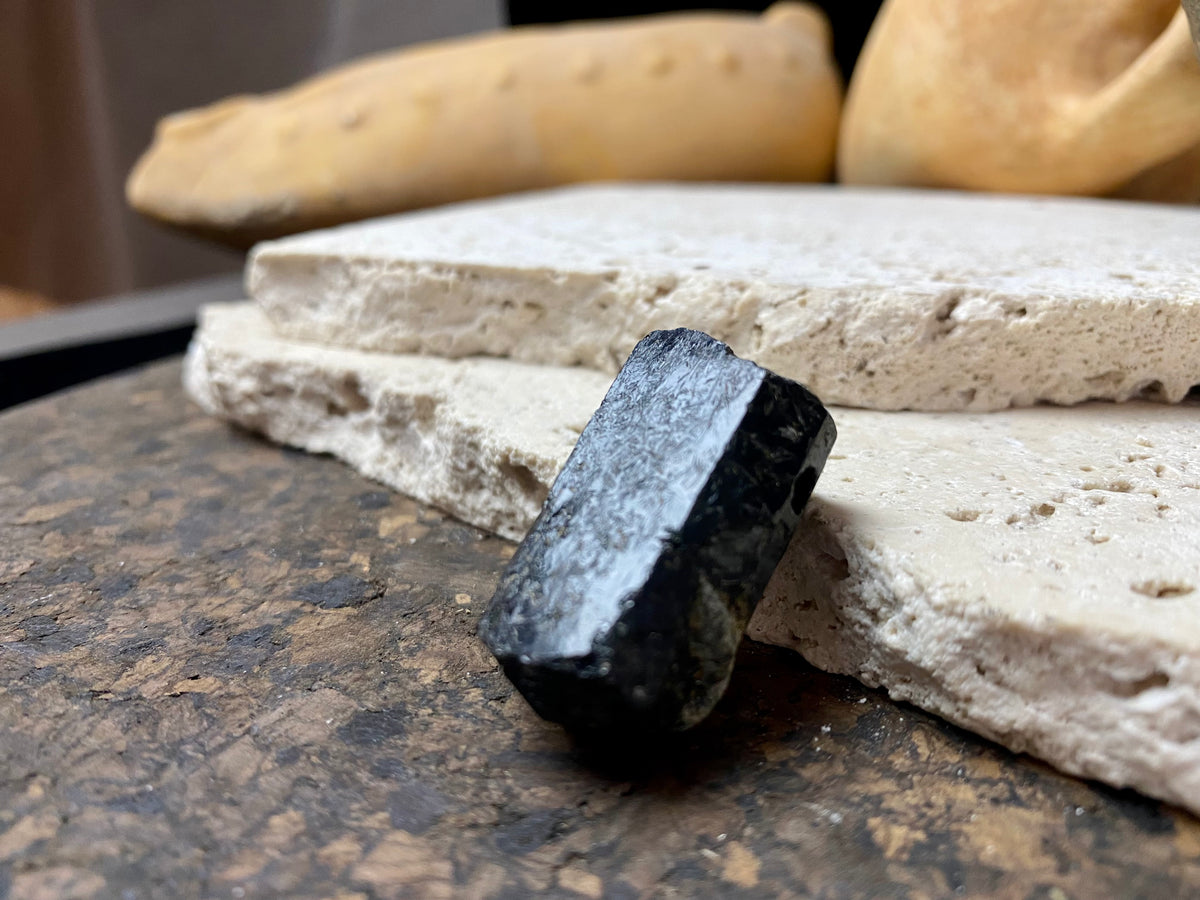 Natural six sided black tourmaline crystal. This has a large hole drilled through the top.  Measurements: 3.3 cm length, width 1.4 x 1.8 cm