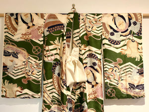 Small, hand sewn child's kimono suitable for either sex. A tasteful design features greens, tans, navy, lilac and pale blue colours in an abstracted design reminiscent of its era. Padded and lined. Hand stitched silk ties with fine thread tassel detailing. No damage, excellent condition. Circa 1950's.