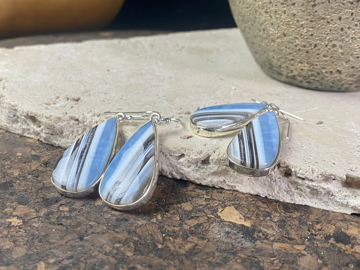 Our stunning earrings feature perfectly matched banded blue opal stones set in sterling silver bezels. Finished with sterling silver hooks.   