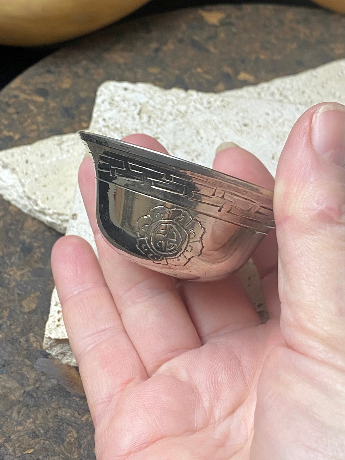 These offering bowls are metal finished with silver plate. They are decorated with repeating etched rim and flower medallions. From Nepal. These make beautiful miniature offering bowls and when filled with sand are perfect for holding incense. Measurements: 3 cm height, diameter at top 6 cm