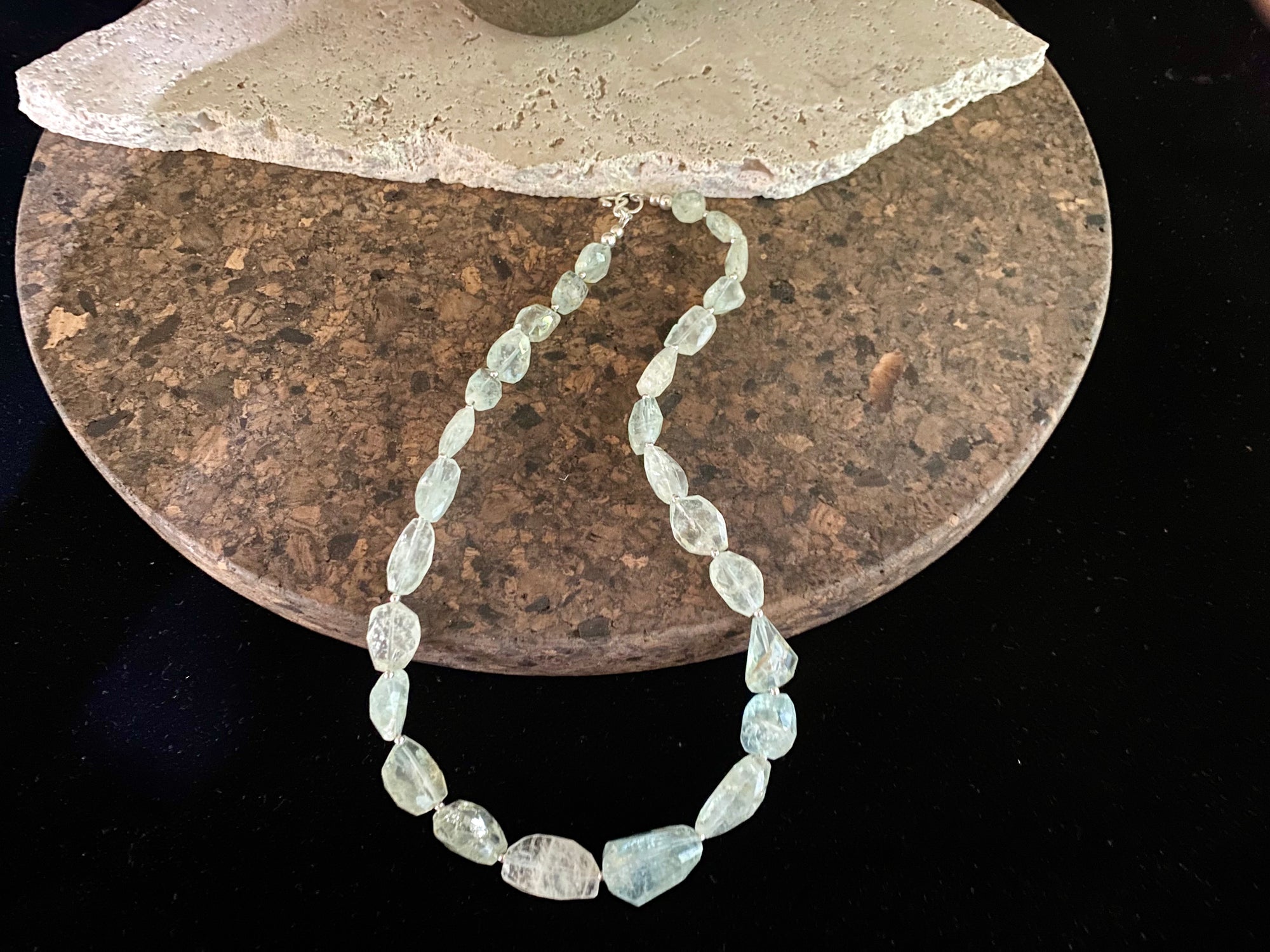 Natural pale blue aquamarine bead necklace featuring a magnificent centre bead and tiny silver bead detailing. Sterling silver findings. The aquamarine beads are matched, graduated, 100% natural and facet cut. They are a very light blue with a colour that changes depending on the angle viewed. 44.5 cm length