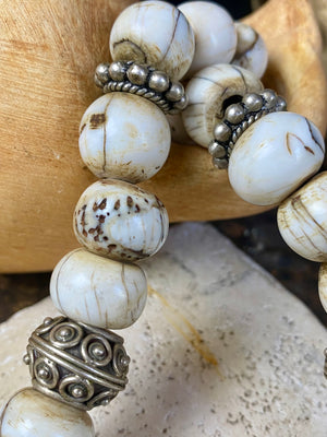 This statement choker necklace inspires Boho chic and features large antique Naga shell beads beads, vintage Indian silver beads and a handmade sterling silver hook. The central bead is an old piece consisting of hand wrapped silver over a wood frame. Length 48 cm