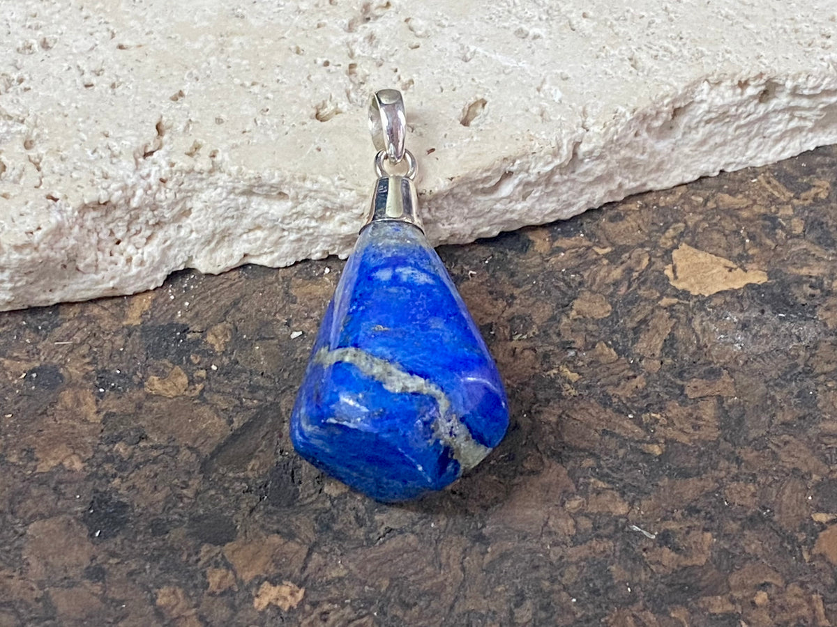 Freeform lapis lazuli top mounted pendant. The rich blue lapis originates from Afghanistan. Set in sterling silver with a generous bail to take a sizeable cord or chain. Height  5.5 cm