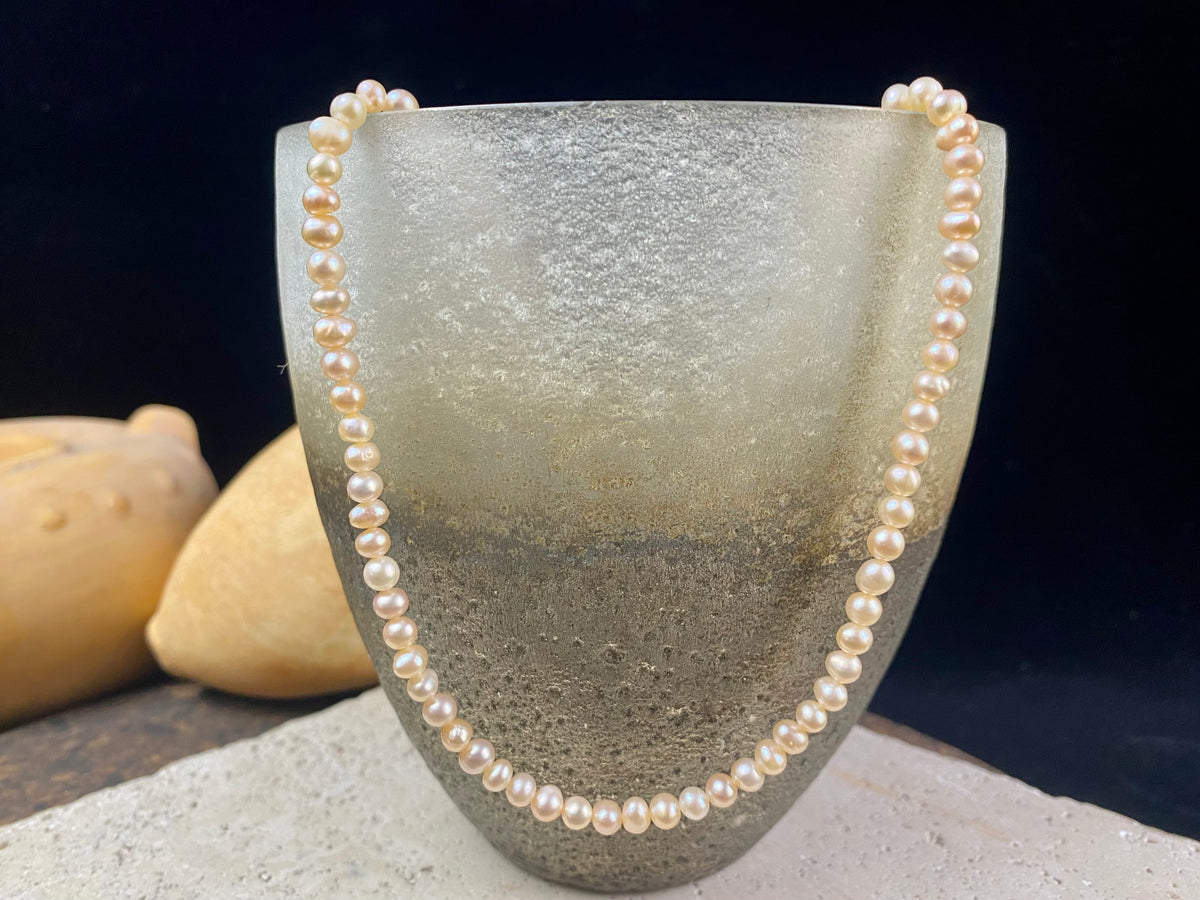 A simple pearl choker necklace, featuring champagne coloured off-round pearls, finished with sterling silver findings and clasp.  These are quality cultured freshwater pearls with a beautiful sheen and thick nacre finish.   Measurements: length 39.5 cm including clasp. Pearls are 4 mm diameter