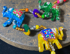 <p>Elephants on strings. Hand painted paper mache elephants, all in different colours. Bell at base, colourful wood beading, cotton pom poms, large loop at the top for hanging. Great gift for kids but really, just perfect to add a touch of colur and Indian styling to any home.</p> <p><strong>Measurements</strong>: Total length 81 cm, elephants are width 6 cm</p>