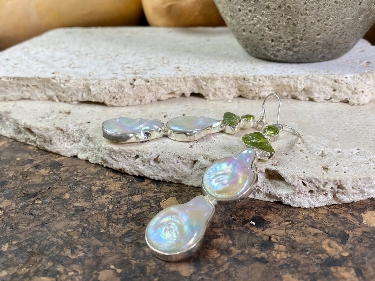 Very long earrings featuring cultured baroque pearls and peridot stones. These statement earrings are set in sterling silver, with sterling silver shepherd hooks. 8 cm length including hooks, width approximately 1.8 cm, depth 0.5 cm