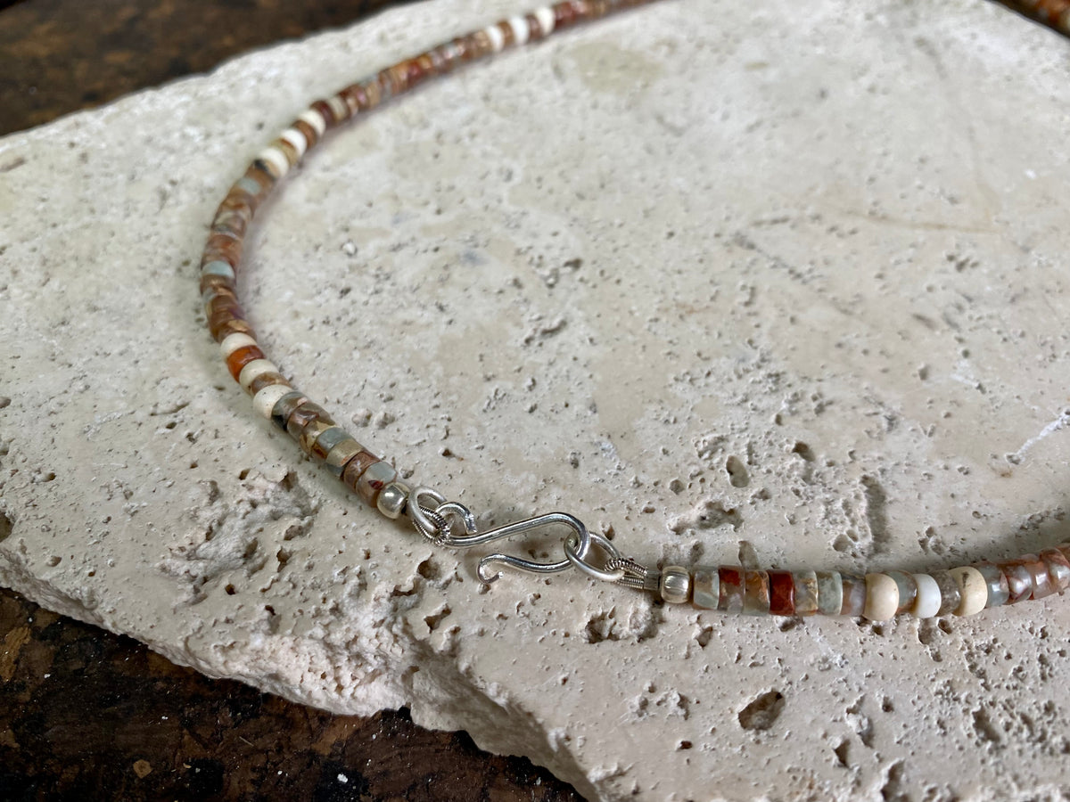 This unique necklace is made from heshi amazonite quartz druzy beads, highlighted with Kachin Burmese shell beads and a pendant made from unpolished onyx. Finished with sterling silver findings and hook clasp. Our necklace will look great on either men or women. Measurements: length including clasp 43.5 cm (17”)