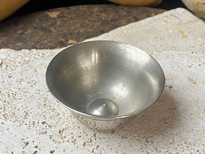 These offering bowls are metal finished with silver plate. They are decorated with repeating etched rim and flower medallions. From Nepal. These make beautiful miniature offering bowls and when filled with sand are perfect for holding incense. Measurements: 3 cm height, diameter at top 6 cm
