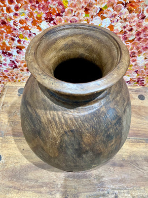 These gracefully shaped pots were used to store lassi, oil, milk, water and grain. This large example comes from northern India and is carved from solid hardwood, in this case most likely teak. Mid 20th century or earlier. slight decoration around the neck and mouth. Repair to the base. Measurements: diameter 22 cm, height 28 cm