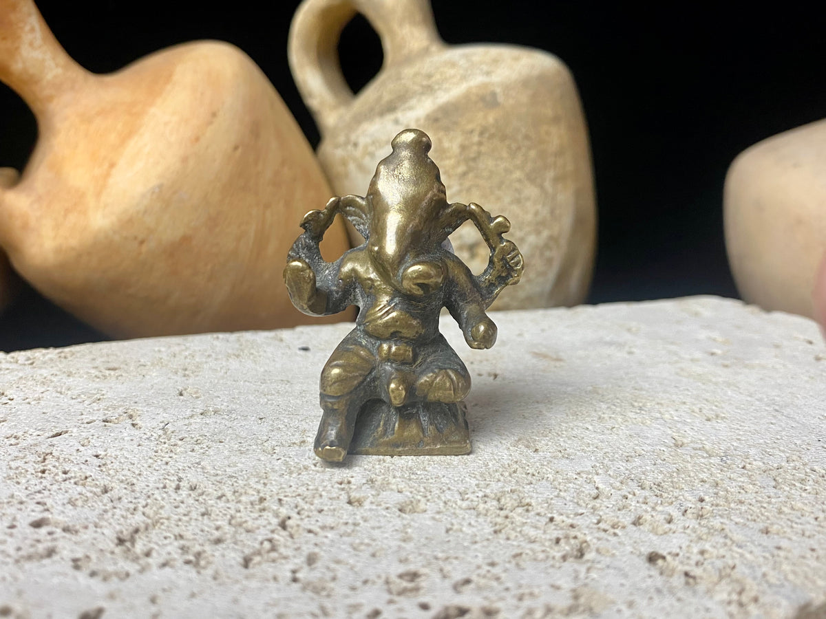 This exquisite mini Ganesh statue features fine, elegant features, and a face softened by many years of rubbing and worship. A beautiful piece. Approximately 100 years old, early 20th century, India, brass alloy.  Measurements: height 6.5 cm, width 3.2 cm, depth 2.5 cm