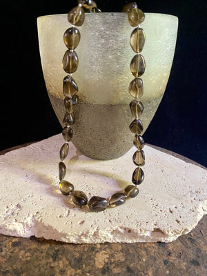This simple necklace is crafted from high quality, tumbled and naturally dark smokey quartz stone and highlighted with sterling silver spacer beads. Finished with sterling silver ends. Measurements: Total length including clasp 50.5 cm