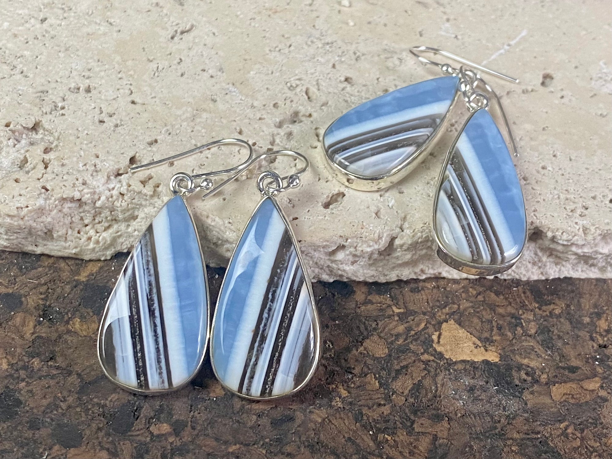 Our stunning earrings feature perfectly matched banded blue opal stones set in sterling silver bezels. Finished with sterling silver hooks.   