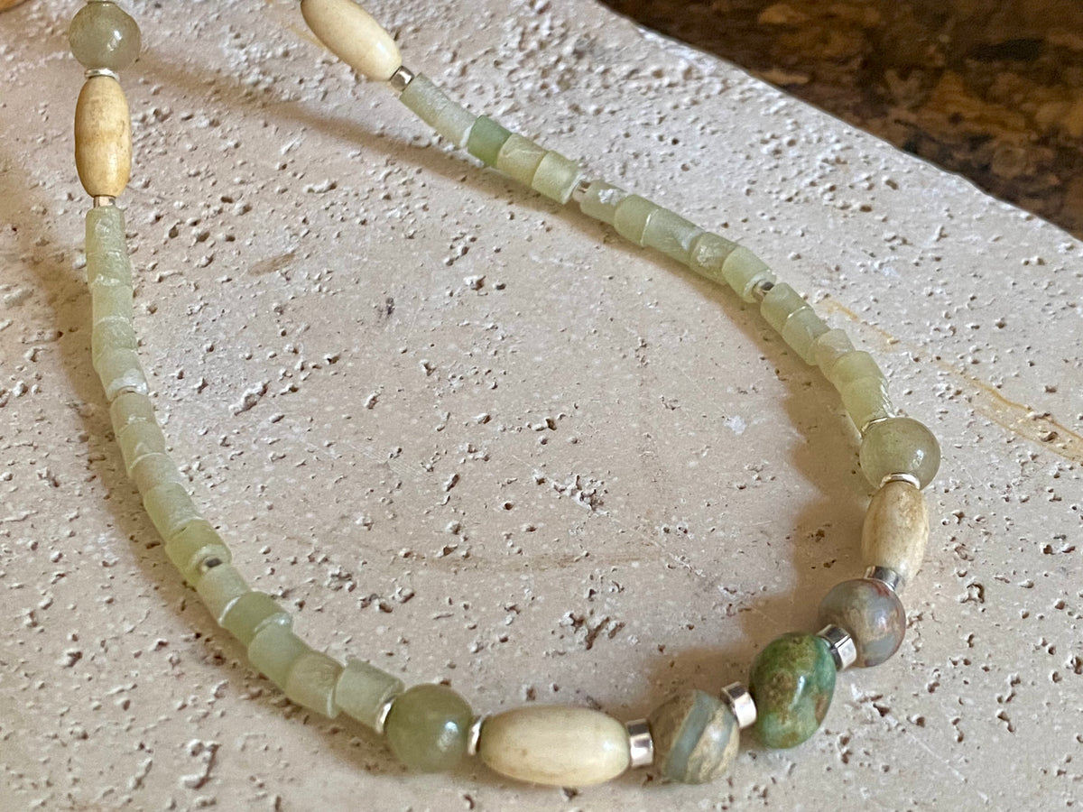 This unique choker features beautiful vintage beads from the Kashgar collection - blue green turquoise centre bead, Ethiopian opal, Bone beads from Burma, Pale green chrysoprase beads, Green serpentine tube beads from Afghanistan and 925 sterling silver detailing and lobster clasp. Length 40.5 cm