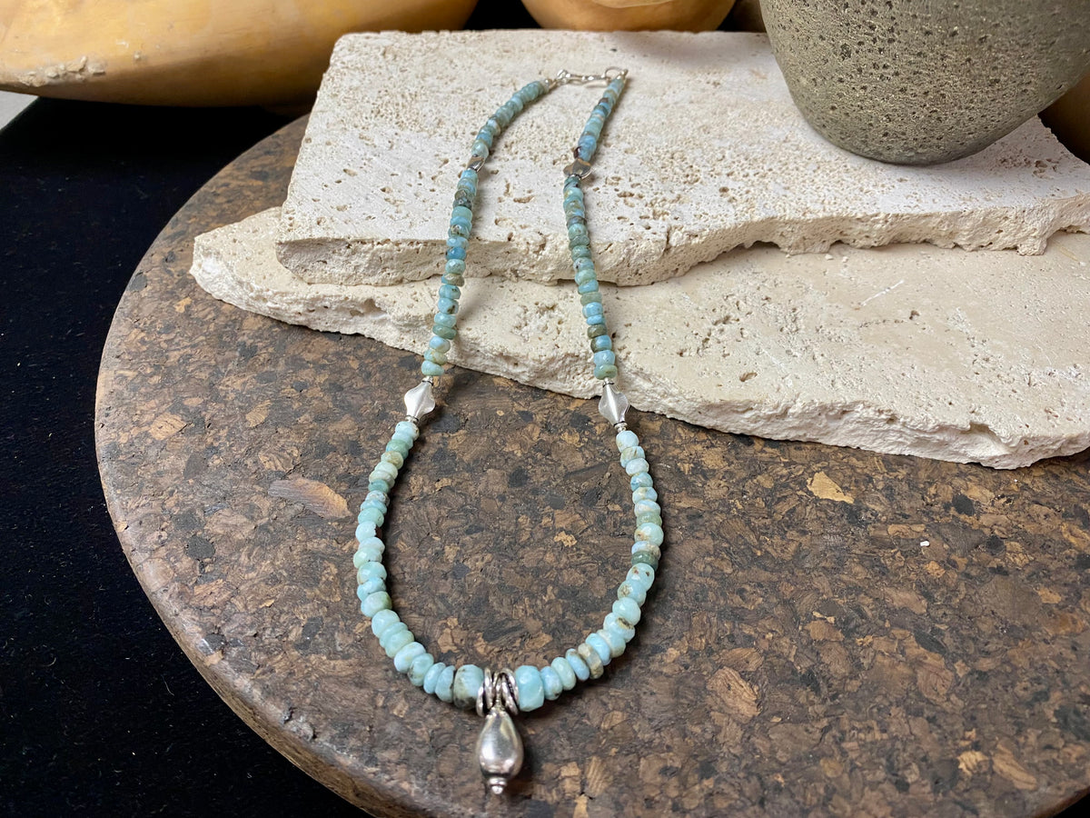 Light blue blue necklace of tumbled, facet cut graduated larimar, highlighted with Rajasthani silver beads and a beautiful central drop pendant. Finished with sterling silver findings and hook clasp. and a hook clasp. Measurements: 46 cm (18") length