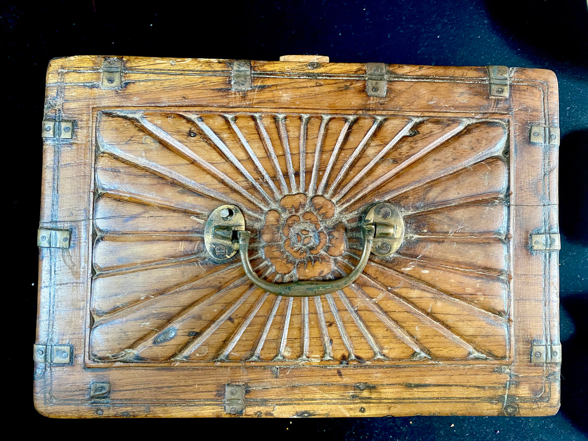 A lovely old southern Indian cash box with carved top and original brass trim, handle and hinges. Fitted with two small shelves inside. Made from teak, this would make a lovely trinket box, key box, jewellery, watch or cufflink box Circa 1880 - 1920. Measurements: length 27.5 cm  x depth 19 cm, height 15 cm.