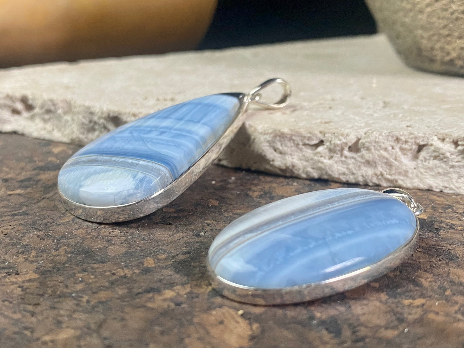 Natural banded blue opal pendants. Set off by sterling silver bezels, topped by generous sized bails large enough to accommodate a thick chain or cord. If you're looking for something a little bit different, this is statement jewellery at its finest.