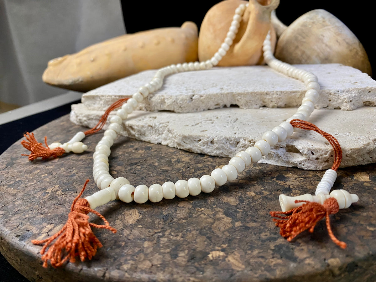Women or men’s mala necklace. Made from buffalo bone, 108 beads and two spacers in the form of the bell and the dorje, symbols of Avalokiteshvara, the Compassionate Buddha.  Total length 64 cm. Fits easily over the head. Bone beads 5 mm diameter