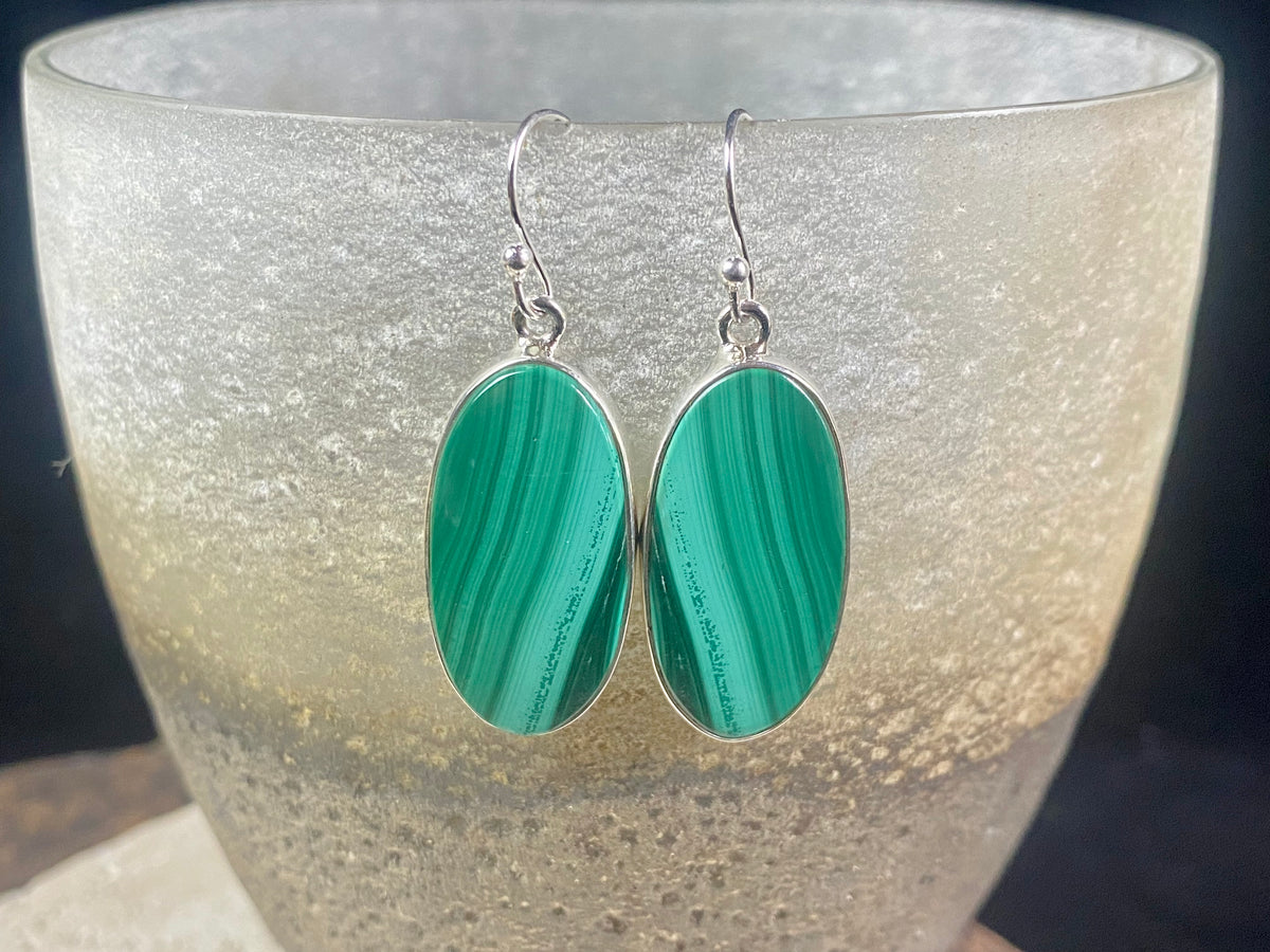 Our elegant earrings feature perfectly matched malachite cabochons set in sterling silver bezels. Finished with sterling silver hooks.